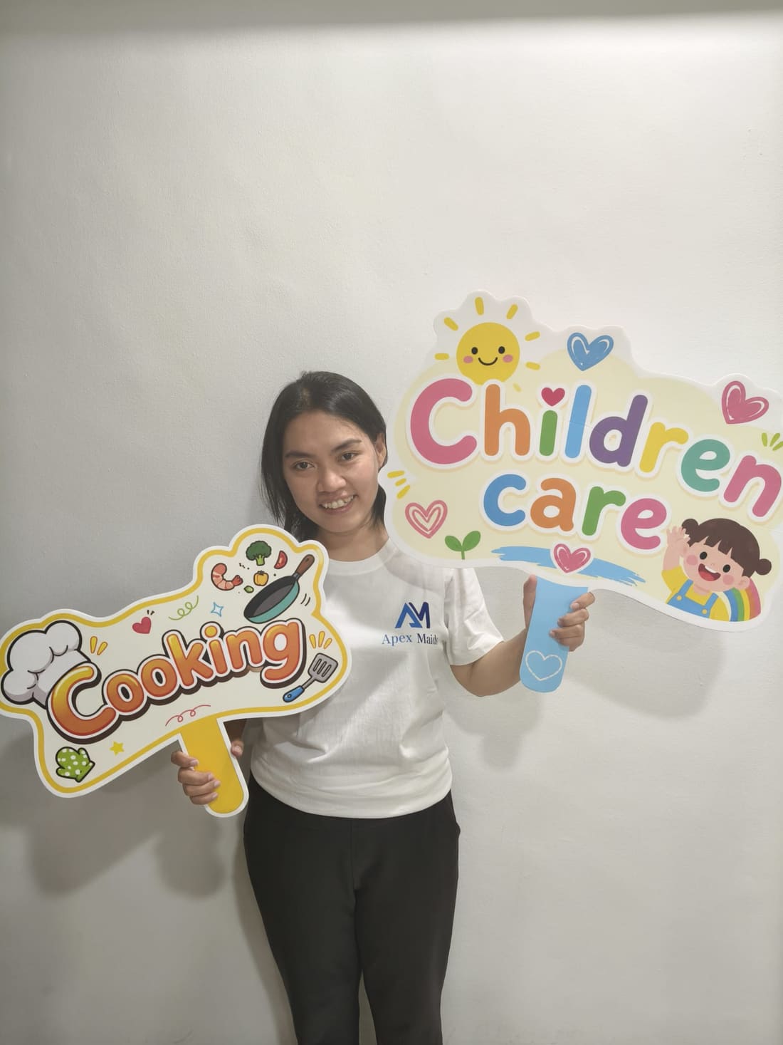 An Apex Maids helper holding cooking and housekeeping service placards