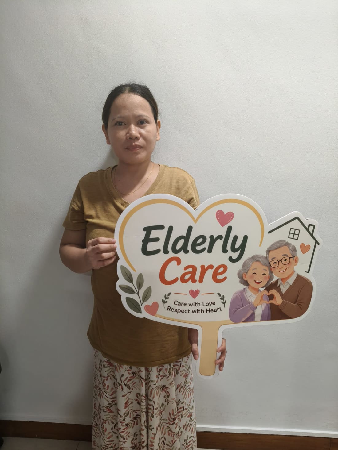 Apex Maids helper holding the Elderly Care placard